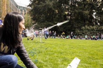 Students with science projects on a green lawn